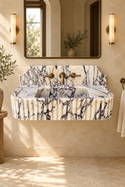 Luxury Calacatta Viola marble fluted wall mounted sink with curved backsplash, natural burgundy veining and brushed gold faucet.