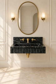 Black marble wall-mounted sink with a fluted front and matching backsplash