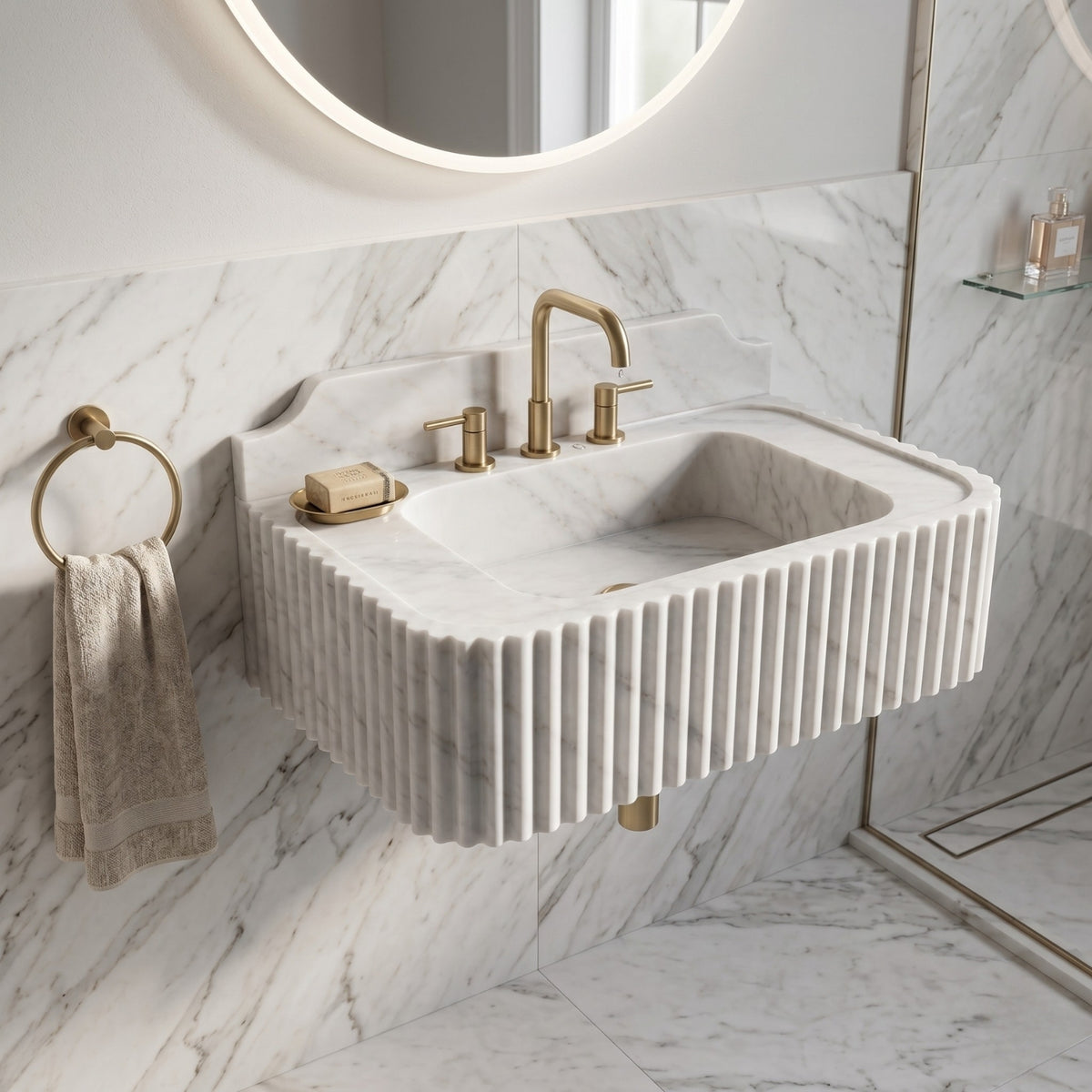 Carrara White marble washbasin with a scalloped fluted front, rectangular bowl, and understated grey veining throughout the stone.