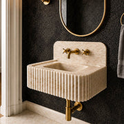 Calacatta Gold marble sink with faucet holes positioned along the rear deck, shown with vertical fluting across the front.